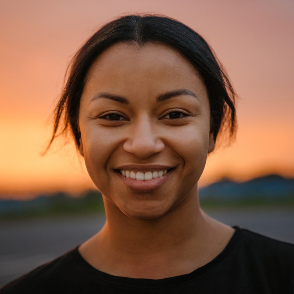 Black brunette woman smiling and looking at camera
